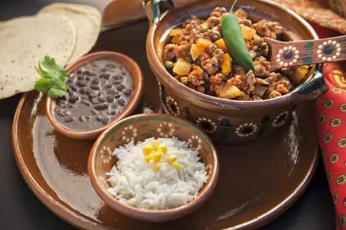 Pork Picadillo served with rice, beans and tortillas